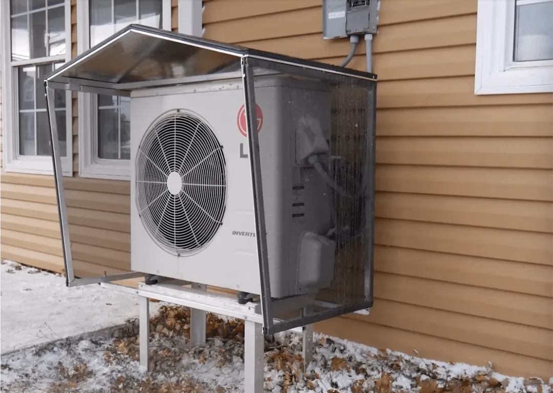 Heat pump snow cover protecting outdoor unit from Canadian winter weather