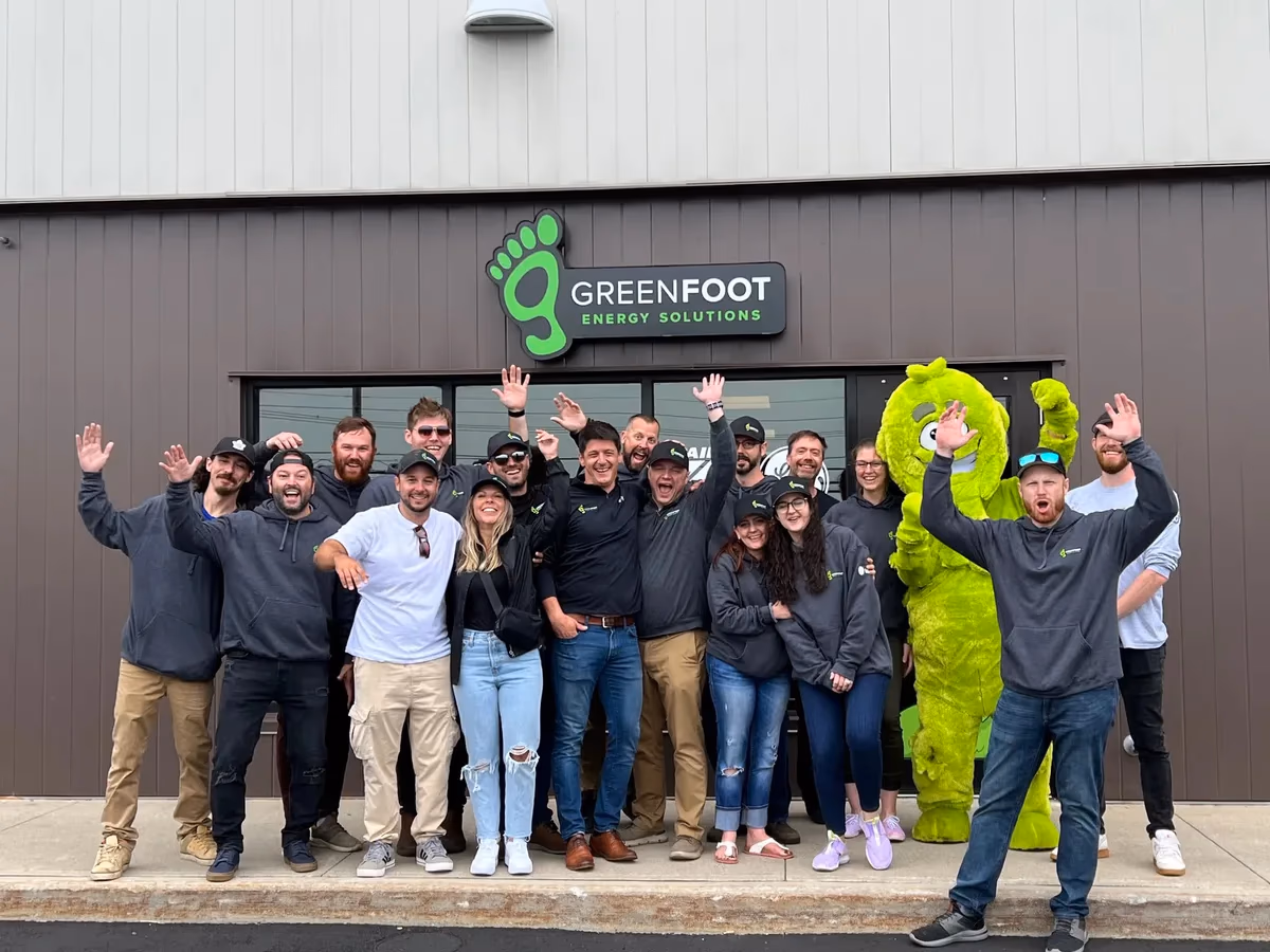 A group of happy Greenfoot Energy Solutions team members posing together